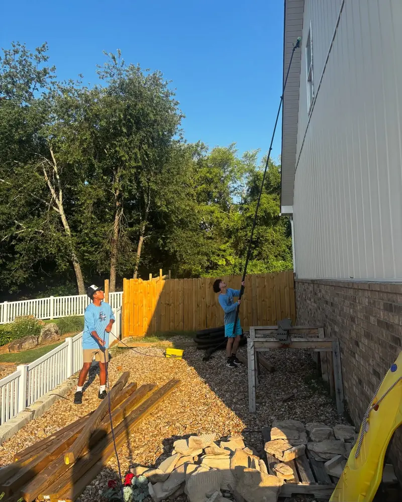 JB crew cleaning second-story windows with a water-fed pole
