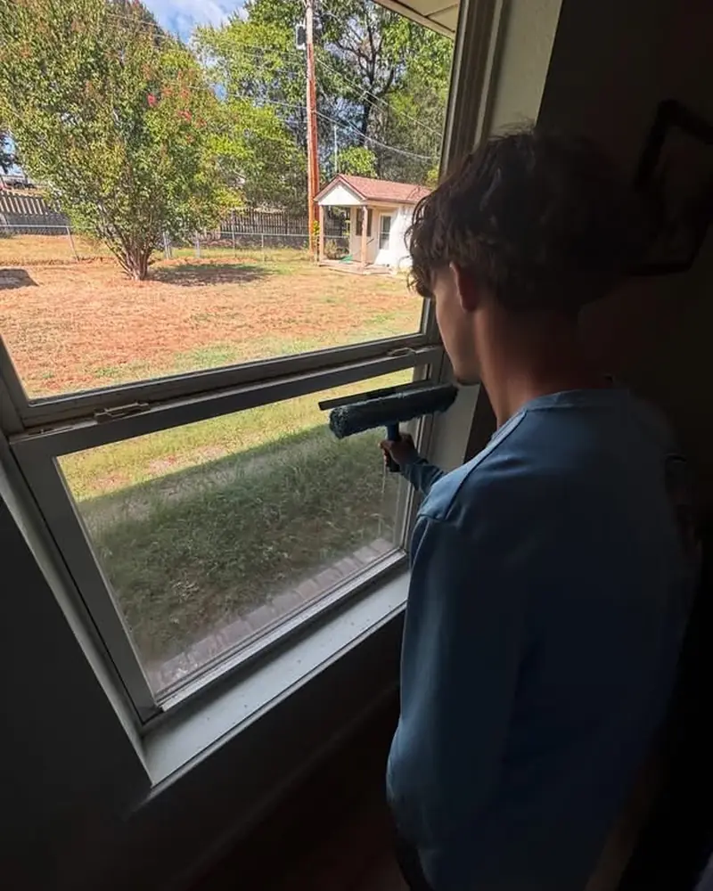 JB crew member squeegeeing an interior window